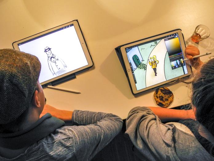2 børn der sidder og tegner på ipad